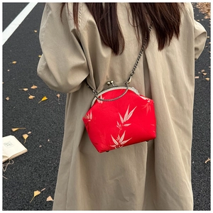Model wearing a vintage red shell bag with white bamboo patterns and bronze chain