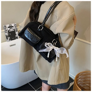 Detail of black vintage tote bag with dual flap pockets and elegant pearl lace charm