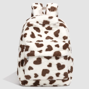 Detailed close-up of soft faux fur backpack featuring brown heart-shaped cow print