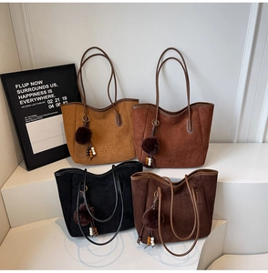 Détail de quatre sacs fourre-tout en daim mat en marron et noir avec des pompons doux