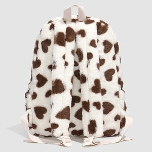 Detail of white plush backpack featuring brown leopard heart pattern and adjustable straps