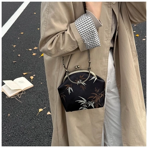 Close-up of vintage black fabric crossbody bag with autumn bamboo embroidery and gold chain