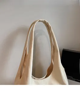 Gros plan sur la bandoulière large et confortable d'un sac cabas minimaliste crème