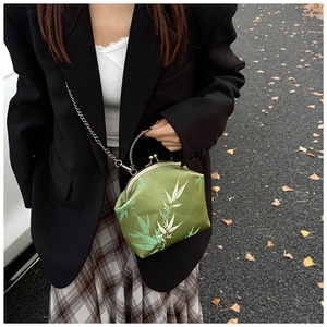 Macro shot of a vintage green shell bag featuring elegant bamboo patterns and chain strap