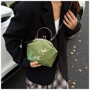 Detail of vintage silk handbag with bamboo leaf print and metal chain strap