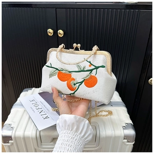 Détail de la broderie élégante de kaki sur le tissu blanc de ce sac traditionnel chic