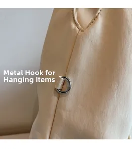 Gros plan sur l'anneau en D métallique d'un sac cabas en toile beige pour accessoires