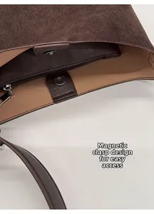 Detail view of the brown suede shoulder bag featuring a secure magnetic snap closure