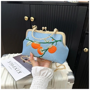 Gros plan du sac à main bleu clair brodé de kakis avec un fermoir en métal doré élégant