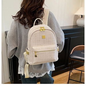 Zaino in tweed rosa con dettagli dorati indossato da modella per scala e stile raffinato