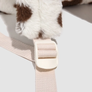 Macro detail of cow print plush backpack featuring durable woven strap and plastic buckle
