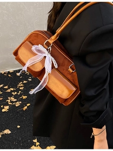 Vintage brown faux suede shoulder bag with lace scarf and pearl charms in model shot