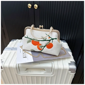 Gros plan de la broderie chinoise traditionnelle de kaki sur un sac blanc chic