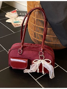 Vintage burgundy velvet underarm bag with patent leather trim and pearl bow charm