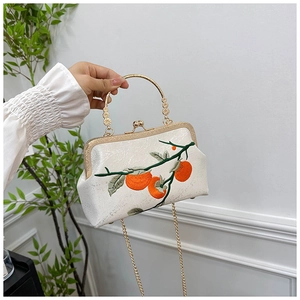 Détail de broderie de kakis sur un sac à main blanc élégant de style chinois