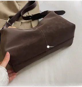 Detail view of brown PU leather hobo bag with vintage texture and stitched seam