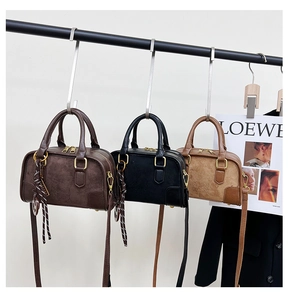 Vue détaillée de trois sacs Boston en marron, noir et camel avec épissure de suède
