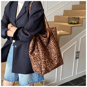 Detail view of large leopard print tote bag with soft suede texture and wide strap
