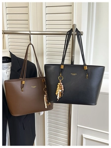 Detail of vintage tote bag set in black and brown with colorful beaded charms and gold hardware