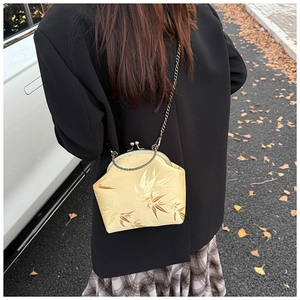 Detail of vintage gold satin crossbody bag with bamboo embroidery and chain strap