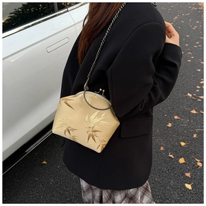 Detail of vintage champagne silk clutch with bamboo embroidery and gold chain strap