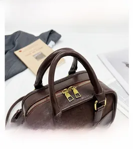 Détail d'un sac Boston marron foncé montrant les textures de cuir et de daim de qualité