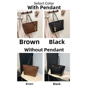 Detail view of large leather tote bag in black and brown with gold hardware accent