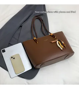 Brown faux leather tote bag size comparison with an iPad and smartphone detail view