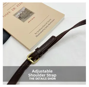 Vue détaillée de la bandoulière réglable en cuir marron foncé avec boucle dorée