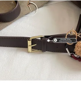 Detail showing the adjustable leather strap with gold metal buckle on a brown shoulder bag