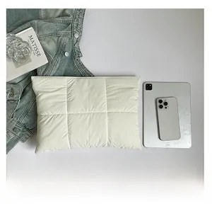 Detailed close-up of quilted off-white nylon sleeve bag for tablet and daily essentials