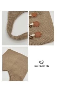 Macro detail of the hand-knitted brown tote bag featuring retro toggle buttons and texture