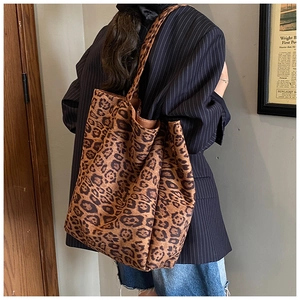 Close-up of leopard print tote bag texture and long shoulder strap in a retro indoor setting
