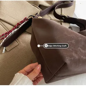 Detailed close-up of large brown hobo bag featuring reinforced pressed edges and woven strap