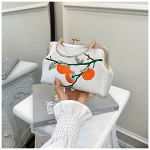 Détail du sac vintage blanc avec broderie de kaki et poignée en métal doré