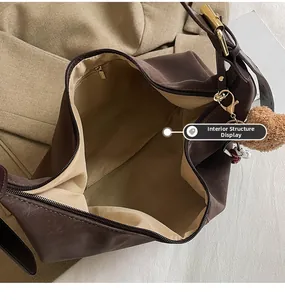 Detail of spacious interior with beige lining and zip pocket on brown dumpling bag