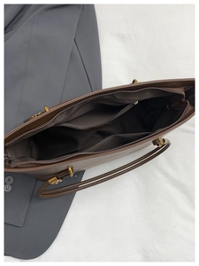 Top view of brown leather tote bag interior showing spacious compartments and zip pocket