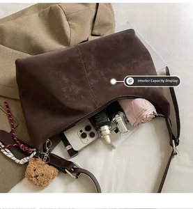 Detail showing the large interior capacity of this brown retro dumpling shoulder bag