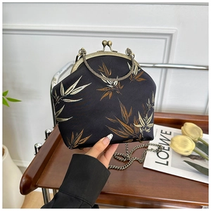 Detail of vintage Chinese style black satin shell bag with bamboo leaf print and chain