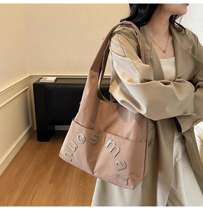 Détail du grand sac cabas en toile avec le logo nuosiman et une grande poche frontale
