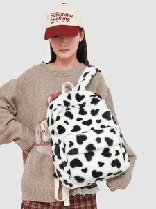 Plush white backpack with black heart patterns and soft fuzzy texture for winter