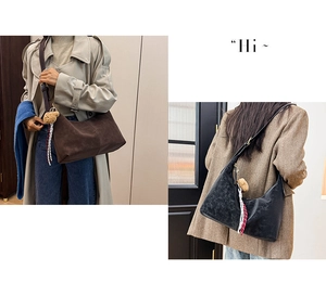 Detail view of coffee and black half-moon shoulder bags with plush bear and ribbon charm