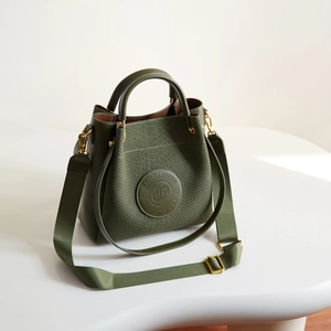 Dettaglio borsa a secchiello verde oliva in pelle a motivo serpente e finiture dorate