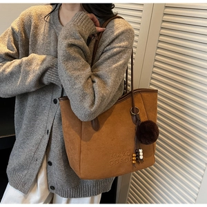Détail du grand sac cabas en daim camel avec gaufrage MKXO COEOR et pompon décoratif