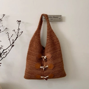 Close-up of brown knit tote bag featuring retro toggle buttons and warm woolly texture
