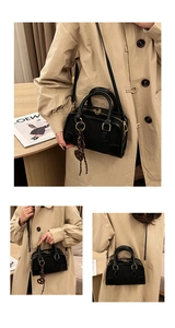 Détails du sac Boston en cuir noir avec garniture dorée et breloque en forme de cœur