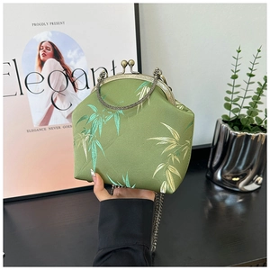 Detail of green satin bag with bamboo embroidery and vintage metal handle