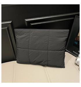 Close-up of dark grey quilted laptop sleeve with high-density anti-shock square stitching
