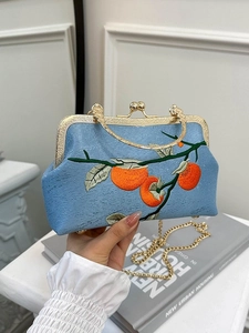 Sac brodé en brocart bleu clair avec poignée dorée et motif de kaki élégant