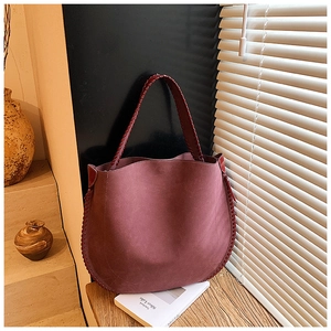 Detail showing hand-woven edge stitching on bordeaux suede large tote bag